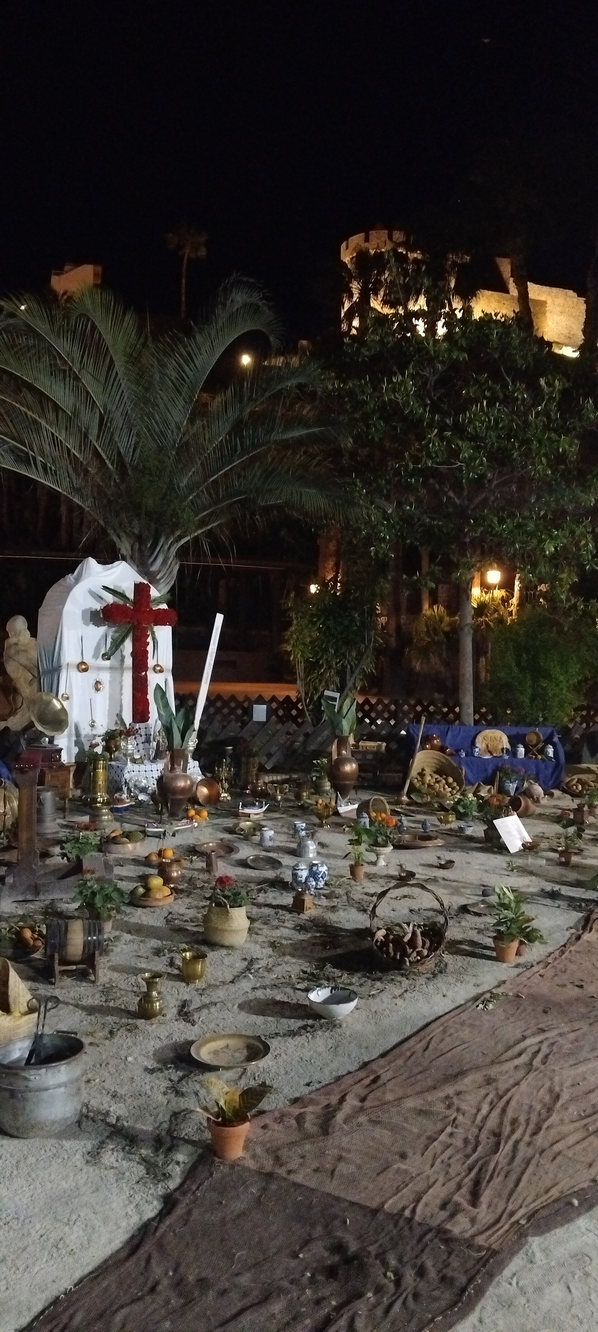 Et blomsterkors til Cruces de Mayo i El Majuelo, med borgen oplyst bag